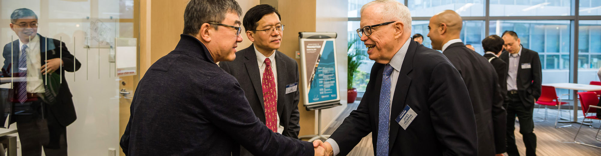 James Heckman speaking with conference attendees.